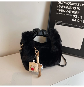 Dettaglio borsa in ecopelliccia nera con manico in PU e ciondolo clown di peluche