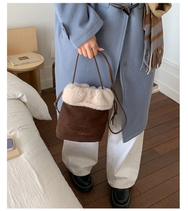 Detail of retro suede bucket bag with faux fur trim and delicate brand metal logo