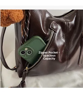 Deep brown glossy leather bag featuring a functional side zipper pocket for smartphones