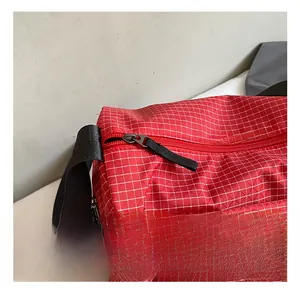 Close-up of red plaid fabric texture and durable black metal zipper puller detail