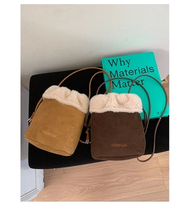 Close-up of vintage suede bucket bags with faux fur trim in brown and coffee colors