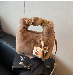 Borsa a mano in peluche marrone con manico a pieghe kaki e ciondolo a forma di clown