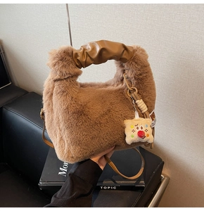 Dettaglio della borsa in peluche marrone con manico arricciato e ciondolo carino