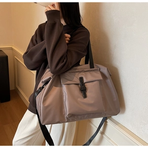 Detail of mauve travel bag with functional buckles and nylon texture for sports