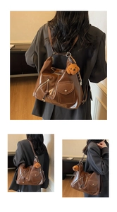 Brown multi-pocket leather backpack with a cute teddy bear plush charm and metal zippers