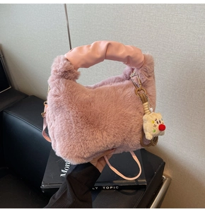 Dettaglio della borsa in ecopelliccia rosa con manico in pelle e ciondolo in peluche