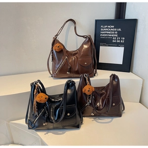 Three vintage oil wax leather tote bags in brown, black, and coffee with bear charms