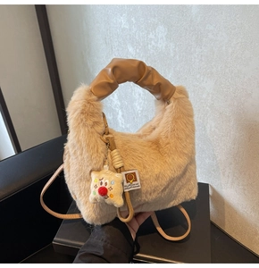Dettaglio della borsa in ecopelliccia beige con manico in pelle e ciondolo a orsetto
