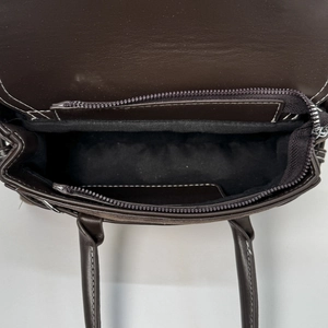 Top view of brown leather bag interior showing zipper compartment and white stitching