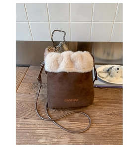 Detail of vintage brown suede bucket bag with faux fur trim and embroidered logo