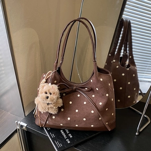 Dettaglio della borsa tote vintage marrone a pois con orsetto e fiocco decorativo