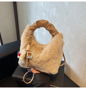 Vista dettagliata della borsa di peluche beige con manici in pelle marrone