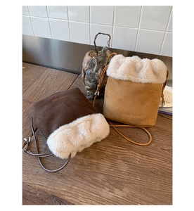Detail of suede bucket bags with plush faux fur trim and adjustable leather drawstring