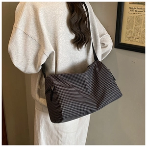 Close-up of lightweight black and white grid crossbody bag with adjustable strap