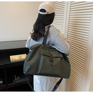 Close-up of olive green large travel bag with adjustable strap and buckle closure
