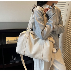 Close-up of cream PU leather tote bag with dual handles and adjustable shoulder strap