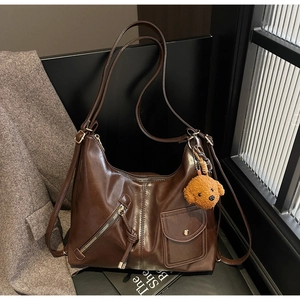 Detailed view of brown vintage PU leather crossbody bag with teddy bear pendant
