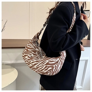Zijaanzicht van zebraprint hobo tas gedragen met zwarte blazer voor een chique look