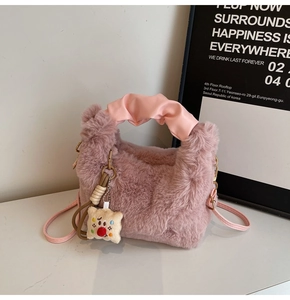 Vista dettagliata della borsa di peluche rosa con manico in pelle arricciata e ciondolo toast