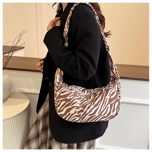 Detailopname van de stijlvolle halve maan tas met zebrapatroon gedragen op outfit
