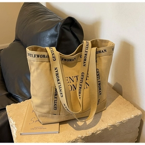 Dettaglio della borsa tote in tela con il logo Gentlewoman nero e la trama del tessuto