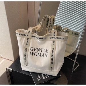 Dettaglio della borsa tote in tela con riflesso del logo Gentle Woman e manici rinforzati