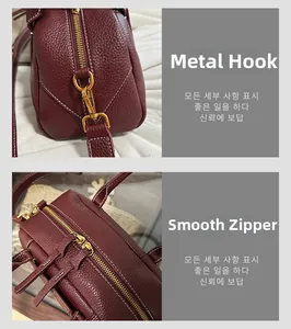 Dettaglio borsa in pelle litchi bordeaux con ganci dorati e cuciture bianche