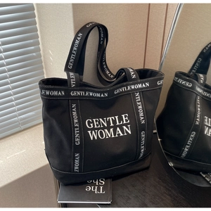 Dettaglio della borsa tote in tela nera con marchio GENTLEWOMAN e doppi manici