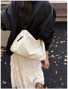 Detailed macro view of the cream quilted pillow bag with high-quality zipper and wide strap