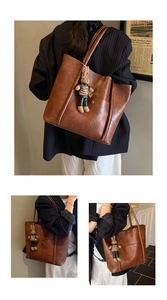 Close-up of brown vintage leather tote bag with a cute rabbit doll pendant detail