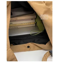Detail view of khaki tote bag interior showing large capacity with books and laptop