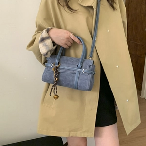 Blue suede shoulder bag featuring white contrast stitching and a decorative charm