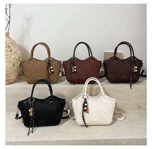 Detail shot of vintage woven bucket bags in five colors with wooden tassel charms