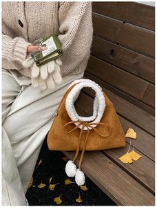 Détail du sac à main en daim marron avec bordure en fausse fourrure blanche