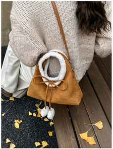 Sac bandoulière en daim marron avec bordure en peluche blanche et pompons pour l'automne
