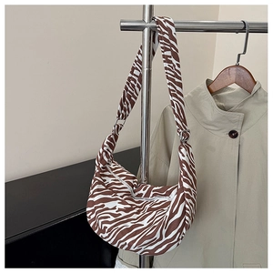 Detail van zebraprint halve maantas met verstelbare riem aan een hanger
