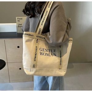 Dettaglio della borsa tote in tela con stampa logo GENTLE WOMAN e tracolla logata larga