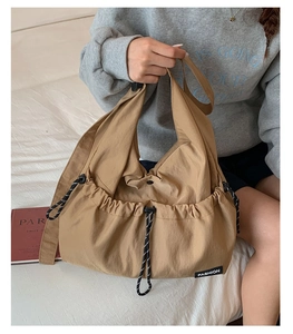 Close-up of khaki drawstring tote bag showing durable nylon material and side pockets