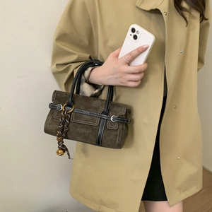 Olive green suede handbag with silk scarf detail and vintage bronze buckle held by model