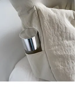 Detailansicht der Seitentasche einer cremefarbenen Umhängetasche aus Waschnylon