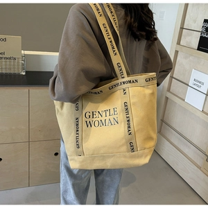 Vista dettagliata della borsa tote in tela con logo GENTLE WOMAN su modella donna