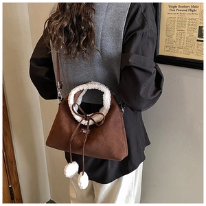 Détail d'un sac bandoulière mat marron avec bordure en similicuir mouton et nœuds
