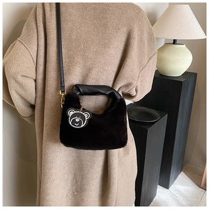 Détail du sac bandoulière en fausse fourrure avec poignée plissée et charm ours