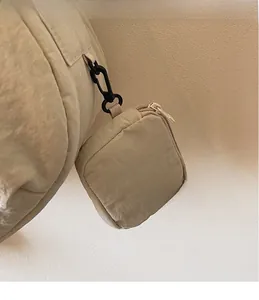 Detail der beigen Nylon-Umhängetasche mit abnehmbarem quadratischem Reißverschlussbeutel