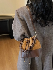 Chic two-tone drawstring bucket bag in brown leather and suede with woven handle