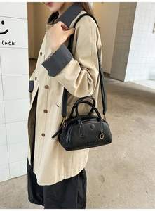 Fashionable black lychee grain crossbody bag worn by a model in a beige trench coat