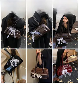Detail shots of vintage glossy leather shoulder bags with lace bow and pearl charms