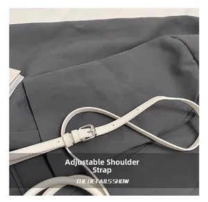 Détail de la bandoulière réglable en cuir blanc cassé avec boucle argentée et perforations