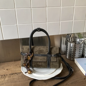 Detail of olive green nubuck handbag with white stitching and PAN'DOR branding