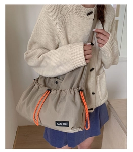 Detail of the high-capacity drawstring crossbody bag with orange nylon cords